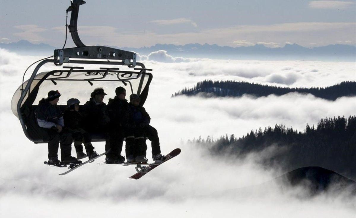 Un grupo de esquiadores y aficionados al snowboard suben en telesilla a la soleada cumbre del Feldberg (Alemania) Un grupo de esquiadores y aficionados al snowboard suben en telesilla a la soleada cumbre del Feldberg (Alemania)