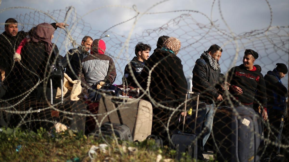 Un grupo de palestinos esperan poder entrar en Egipto por el paso fronteriza de Rafa.