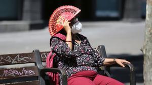 Una señora se protege del sol, ante la ola de calor, en las Ramblas de Barcelona. 