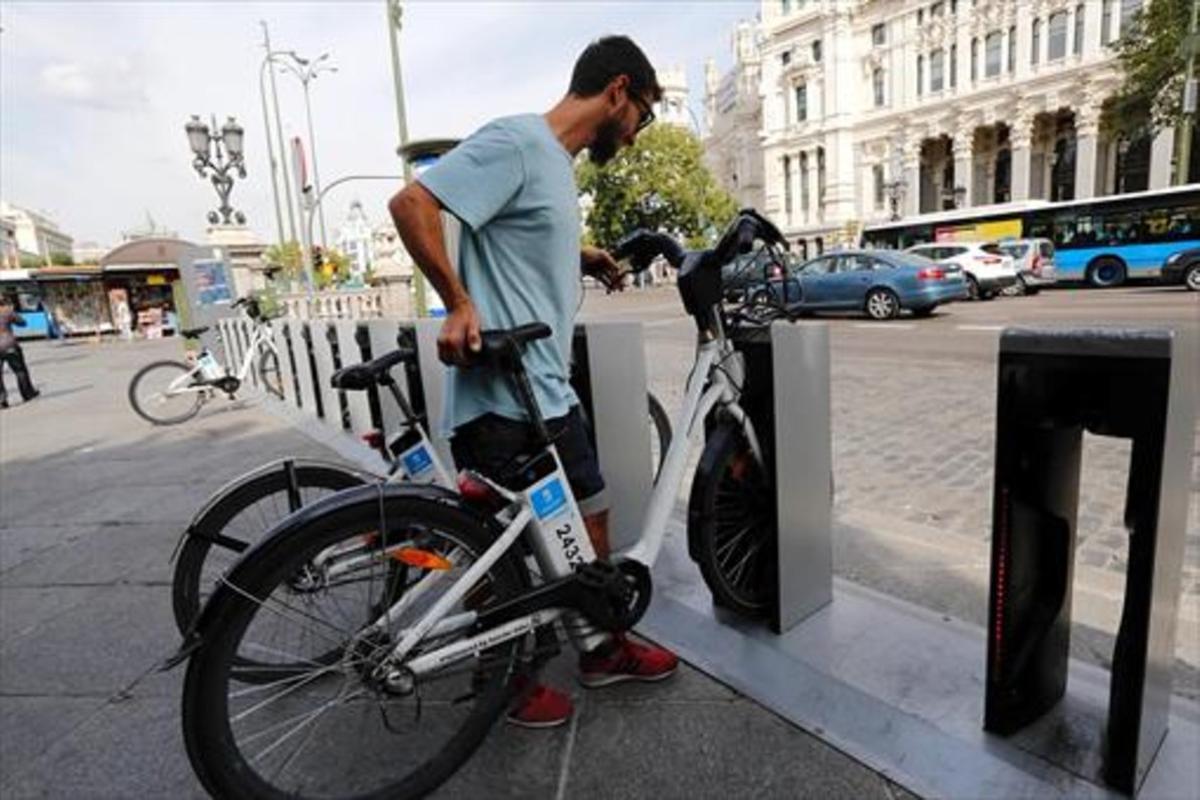 Un usuario del BiciMad se dispone a coger una bicicleta en el centro de Madrid.