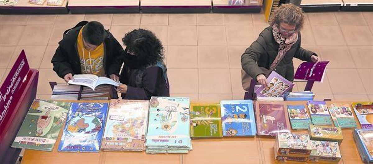 Unos clientes consultan libros de texto en una tienda Abacus, en Barcelona. Unos clientes consultan libros de texto en una tienda Abacus, en Barcelona.