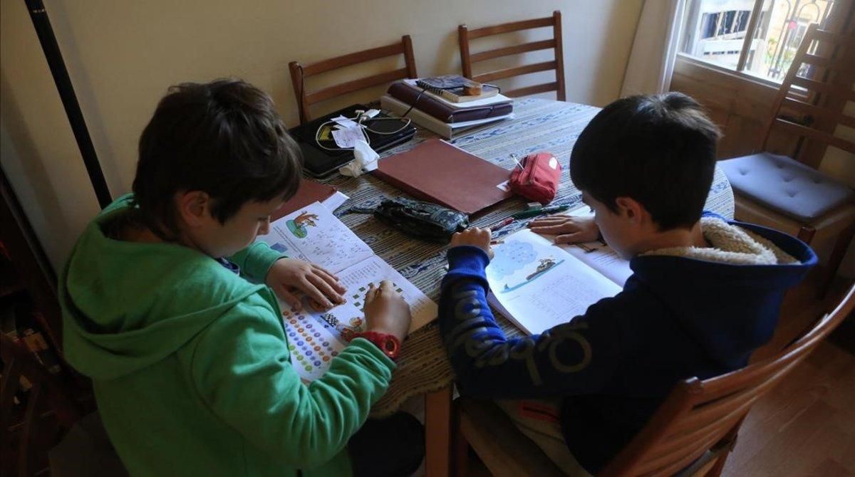 Unos niños haciendo deberes. Unos niños haciendo deberes.