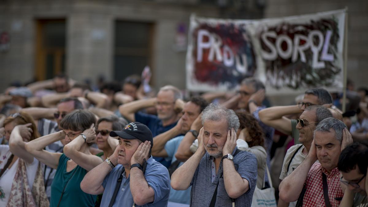 Los manifestantes se tapan los oídos durante la concentración de protesta frente al ayuntamiento. 