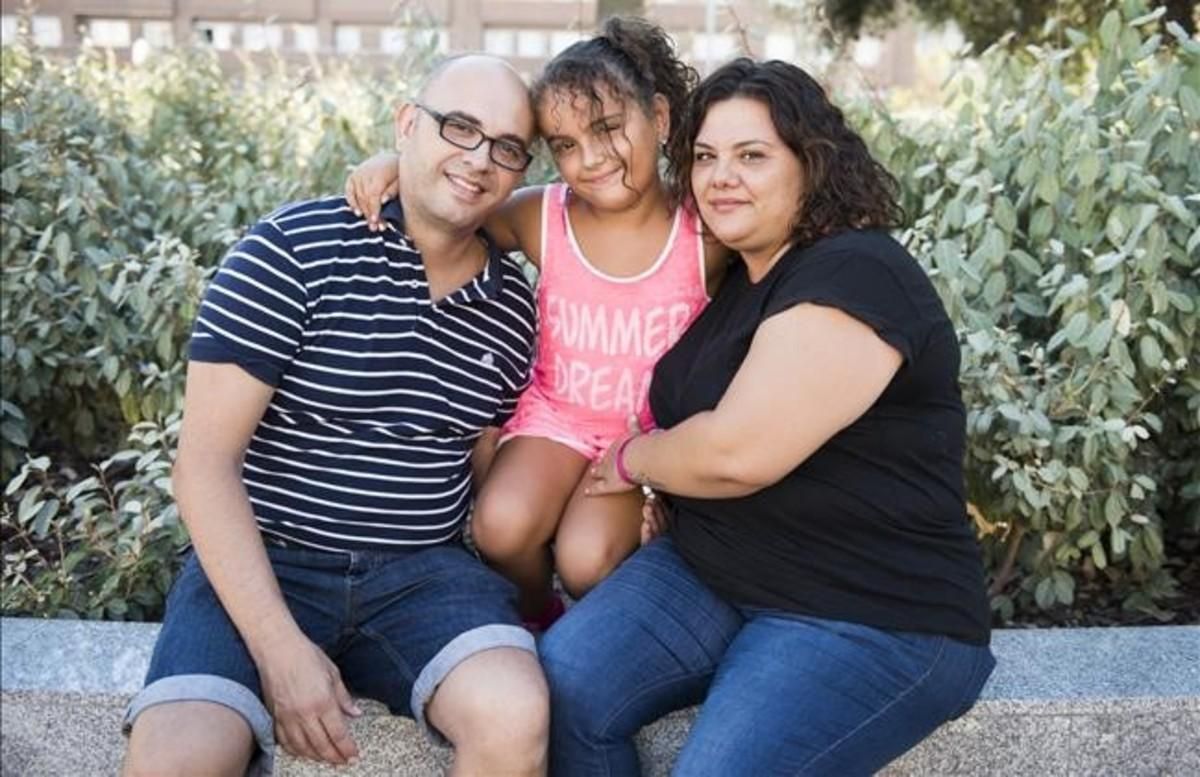 Erika Valero, de ocho años, junto con sus padres Javier y Cristina, en un parque de Badalona. Erika Valero, de ocho años, junto con sus padres Javier y Cristina, en un parque de Badalona.