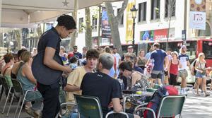 Un camarero antiende a unos clientes en Las Ramblas de Barcelona. 