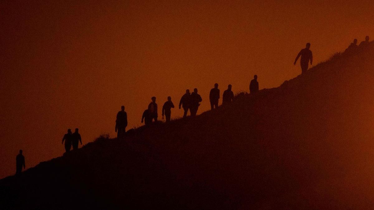 Migrantes caminan por un acantilado en Fnideq, con la intención de cruzar a España desde Ceuta. Migrantes caminan por un acantilado en Fnideq, con la intención de cruzar a España desde Ceuta.