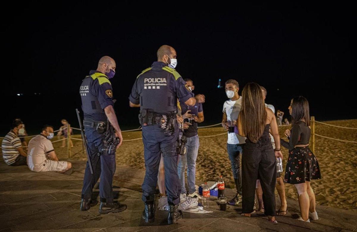 Agentes de policía advierten a jóvenes que están bebiendo en la playa de la Nova Icària, a las 23.40 horas del 23 de julio. Agentes de policía advierten a jóvenes que están bebiendo en la playa de la Nova Icària, a las 23.40 horas del 23 de julio.