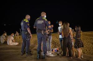 Agentes de policía advierten a jóvenes que están bebiendo en la playa de la Nova Icària, a las 23.40 horas del 23 de julio.