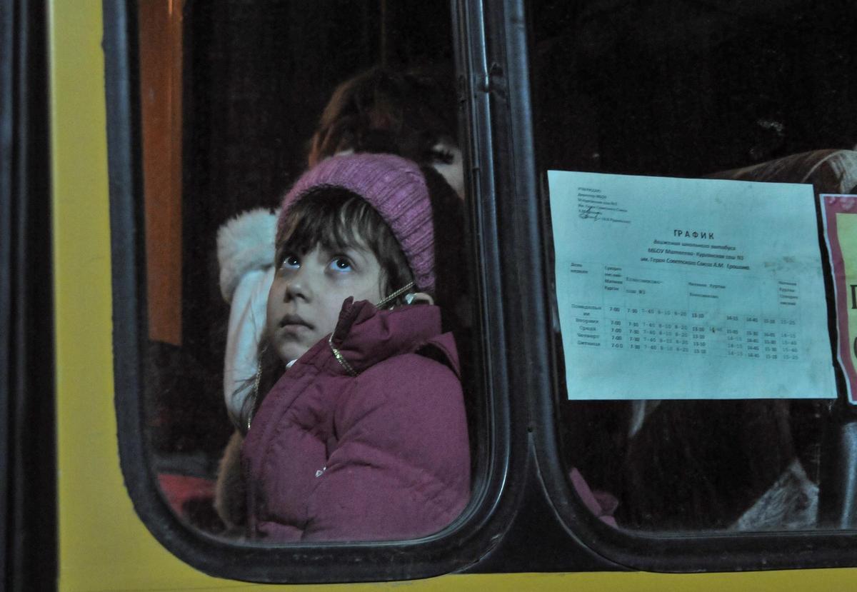 Una niña procedente de la autoproclamada república separatista de Donetsk aguarda dentro de un autobús en el puesto aduanero de Matveev Kurgan, en la región rusa de Rostov, en febrero de 2022. Una niña procedente de la autoproclamada república separatista de Donetsk aguarda dentro de un autobús en el puesto aduanero de Matveev Kurgan, en la región rusa de Rostov, en febrero de 2022.