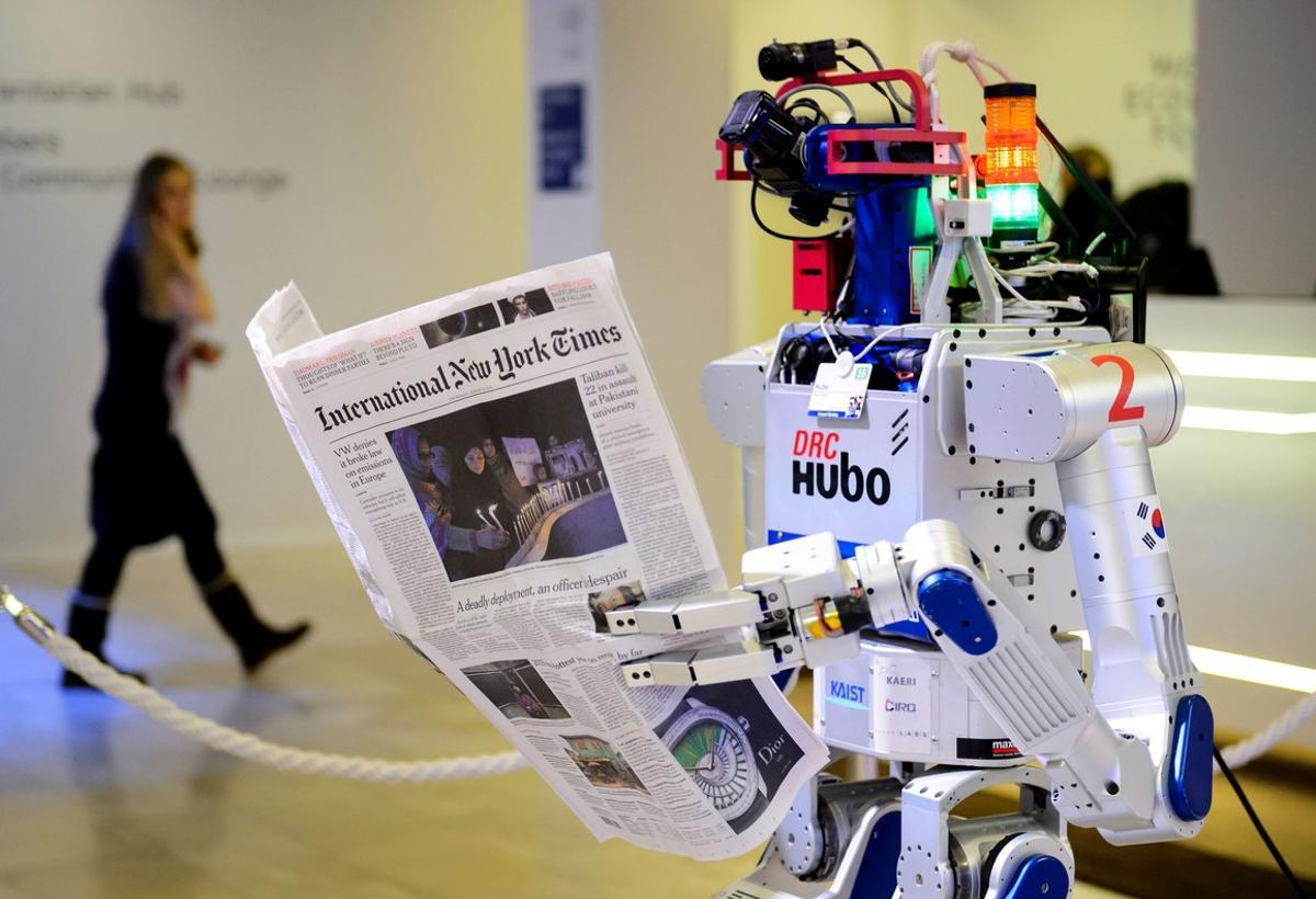  Un robot sostiene un periódico durante una exhibición en Davos, el pasado enero.