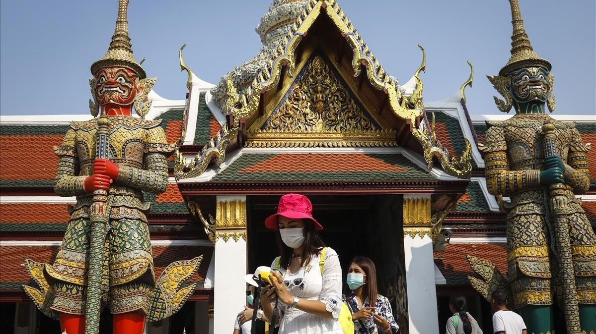 Turistas con mascaras junto al Palacio Real de Bangkok, este sábado. Turistas con mascaras junto al Palacio Real de Bangkok, este sábado.