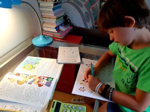 Un niño de 2º de primaria realiza en casa los deberes de matemáticas.