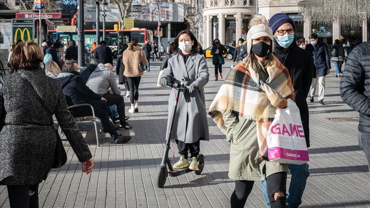 Una mujer circula en patinete por la acera en el centro de Barcelona, el 4 de enero Una mujer circula en patinete por la acera en el centro de Barcelona, el 4 de enero