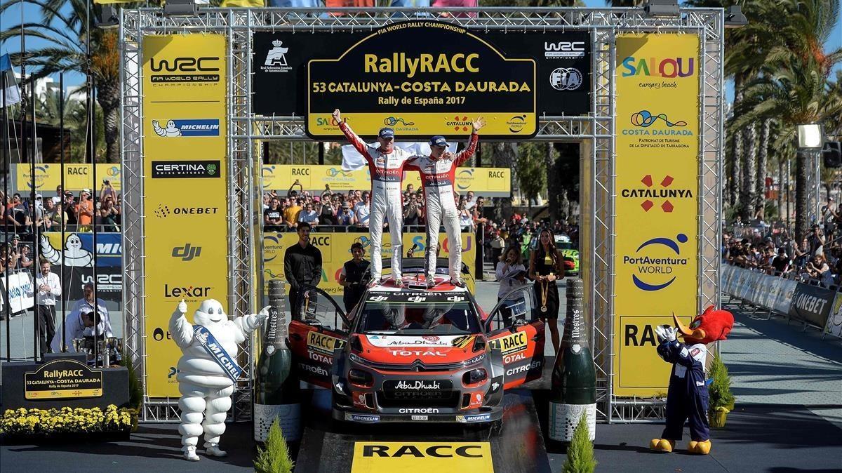Kris Meeke (derecha) y su copiloto Paul Nagle celebran el triunfo en el Rally de Catalunya sobre el capó de su Citroën.