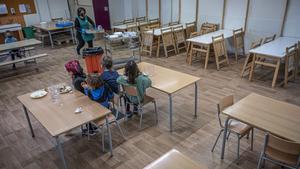 Varios niños, en el comedor, prácticamente vacío, de la escuela Fructuós Gelabert de Barcelona.