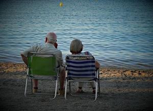 Una pareja de jubilados descansa en la playa.