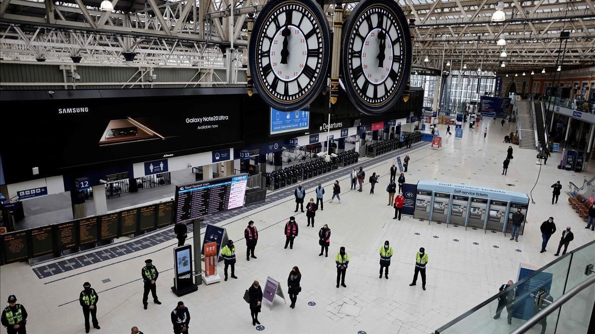 Viajeros y trabajadores participan en un minuto de silencio en el primer aniversario del cierre nacional por covid-19 en la estación de Waterloo, en el centro de Londres. Viajeros y trabajadores participan en un minuto de silencio en el primer aniversario del cierre nacional por covid-19 en la estación de Waterloo, en el centro de Londres.