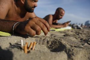 Barcelona prohibirá fumar en cuatro de sus playas. Así lo explica el concejal Eloi Badia. En la foto, fumadores en la playa de la Barceloneta.