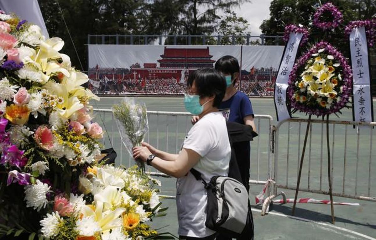 Dos mujeres colocan flores en el memorial a las víctimas de Tiananmen, en Hong Kong. Dos mujeres colocan flores en el memorial a las víctimas de Tiananmen, en Hong Kong.