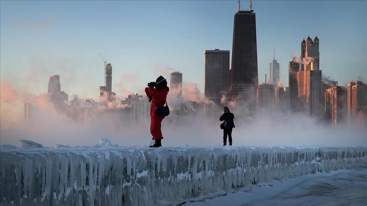 Dos fotógrafos toman imágenes de la tormenta sobre la ciudad de Chicago.
