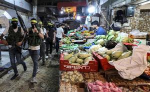 Militantes enmascarados de Fatah marchan a través de un antiguo mercado en el centro de la ciudad de Nablus