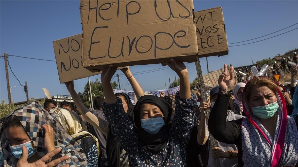 Una mujer refugiada de Moria muestra en una protesta un cartón en el que hay escrito en inglés Europa ayúdanos. Una mujer refugiada de Moria muestra en una protesta un cartón en el que hay escrito en inglés Europa ayúdanos.