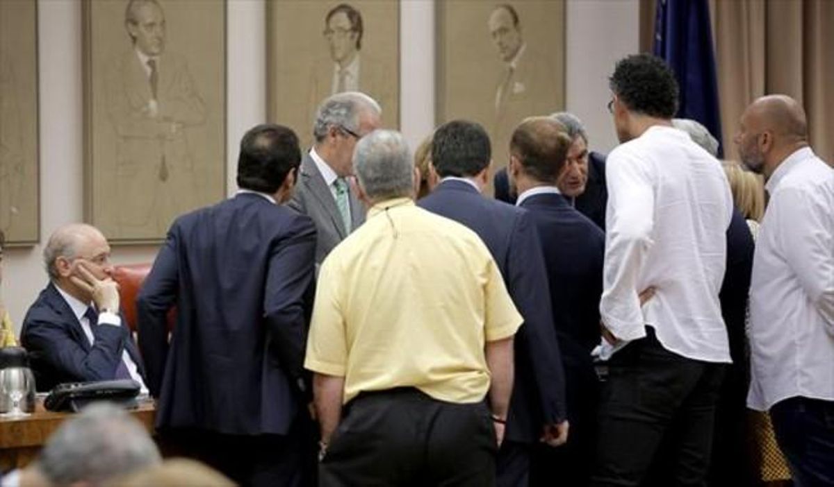 Los portavoces de los grupos hablan con el presidente de la comisión, ante la mirada del ministro, ayer en el Congreso. Los portavoces de los grupos hablan con el presidente de la comisión, ante la mirada del ministro, ayer en el Congreso.