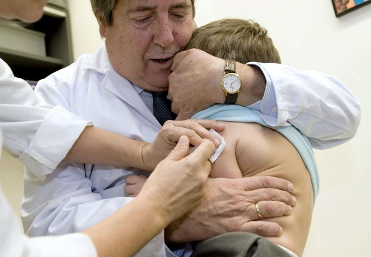 Un nen rep una vacuna antigripal en un centre de salut.