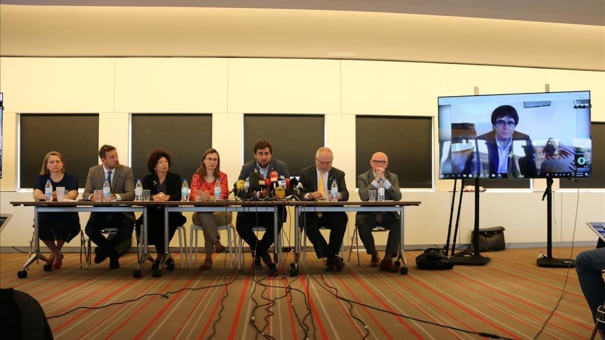 Toni Comín, Meritxell Serret y Lluís Puig junto a los abogados belgas del equipo de defensa y Carles Puigdemont a la pantalla durante la rueda de prensa de hoy en Bruselas Toni Comín, Meritxell Serret y Lluís Puig junto a los abogados belgas del equipo de defensa y Carles Puigdemont a la pantalla durante la rueda de prensa de hoy en Bruselas