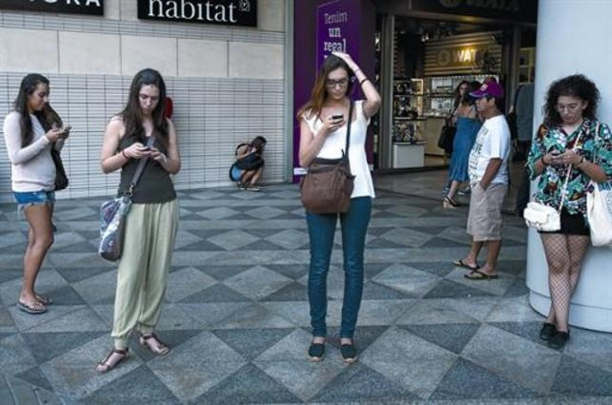 Cuatro ciudadanas consultan sus ’smartphones’ en la plaza de Catalunya, en Barcelona. Cuatro ciudadanas consultan sus ’smartphones’ en la plaza de Catalunya, en Barcelona.
