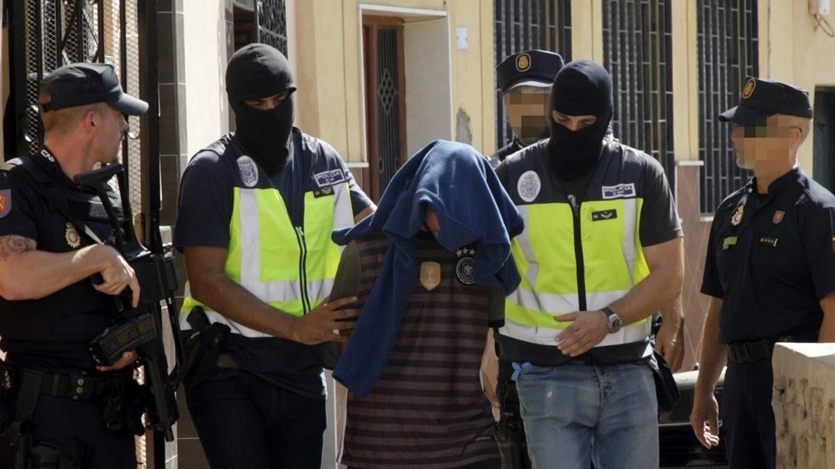 Efectivos de la Policia Nacional traslada a una persona detenida durante el registro realizado hoy en un domicilio del barrio periferico del Monte Maria Cristina de Melilla en el marco de una operacion antiterrorista que se esta llevando a cabo en Melilla en la que tambien se ha producido un registro en la calle de Garcia Cabrelles La Policia Nacional y la Direccion General de Seguridad de Marruecos han desmantelado una celula yihadista integrada por seis presuntos terroristas en una operacion en la que han sido detenidas cinco personas en Marruecos y otra en Melilla Efectivos de la Policia Nacional traslada a una persona detenida durante el registro realizado hoy en un domicilio del barrio periferico del Monte Maria Cristina de Melilla en el marco de una operacion antiterrorista que se esta llevando a cabo en Melilla en la que tambien se ha producido un registro en la calle de Garcia Cabrelles La Policia Nacional y la Direccion General de Seguridad de Marruecos han desmantelado una celula yihadista integrada por seis presuntos terroristas en una operacion en la que han sido detenidas cinco personas en Marruecos y otra en Melilla