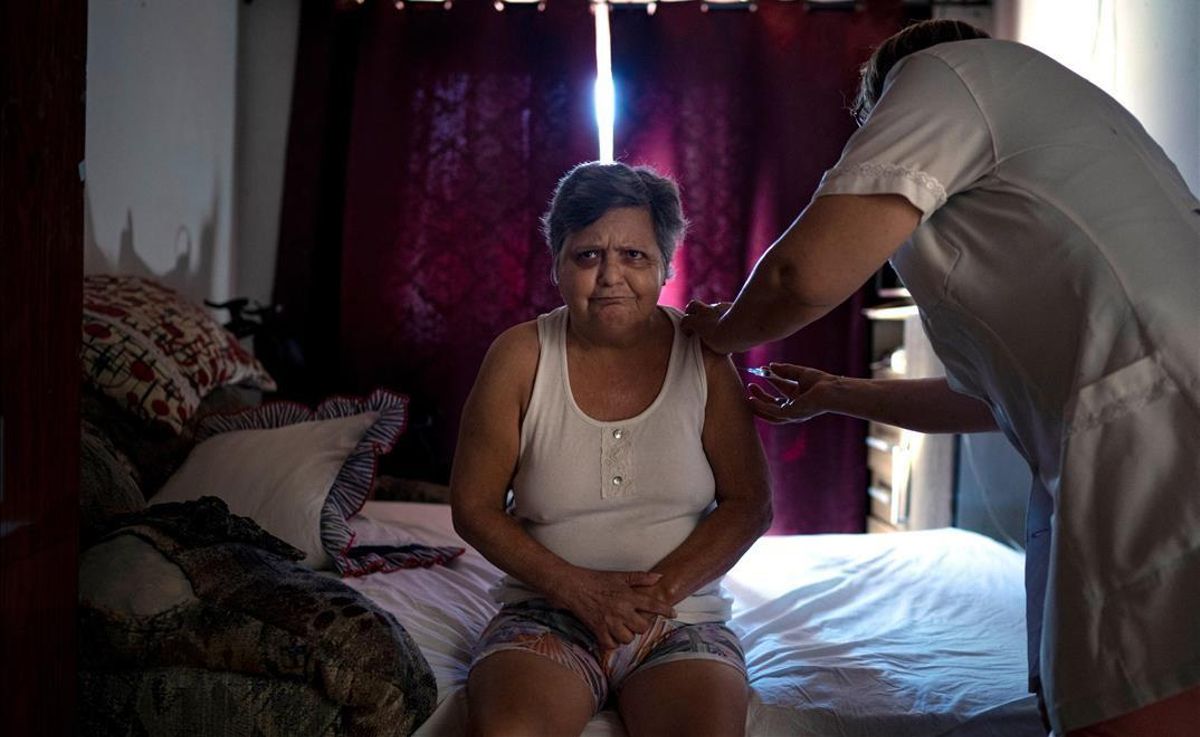 Una mujer recibe en su casa la primera dosis de la vacuna de Coronavac contra la covid-19, en Sao Leopoldo (Brasil). Una mujer recibe en su casa la primera dosis de la vacuna de Coronavac contra la covid-19, en Sao Leopoldo (Brasil).