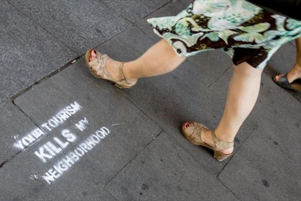 Pintada contra el turismo invasivo y los pisos turísticos en una calle de la Barceloneta. Pintada contra el turismo invasivo y los pisos turísticos en una calle de la Barceloneta.