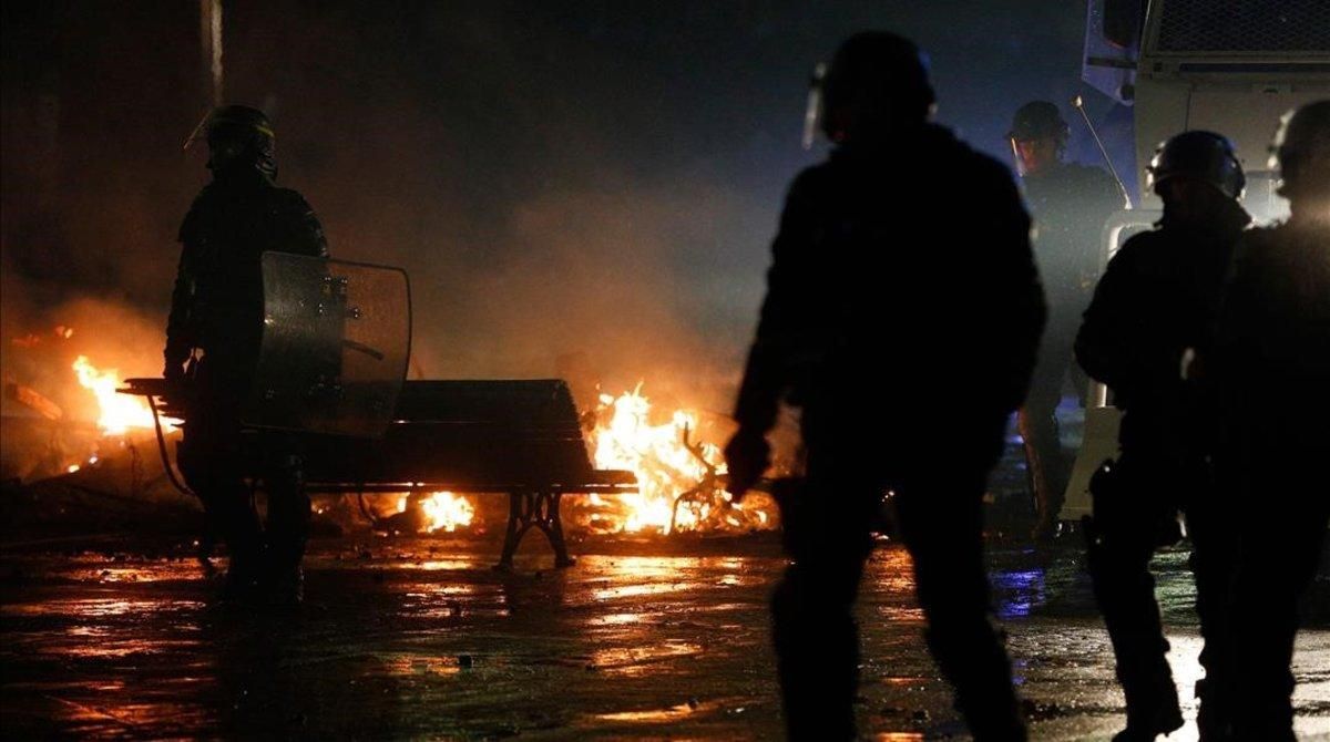 Policías antidisturbios frente a una barricada en llamas en París. Policías antidisturbios frente a una barricada en llamas en París.