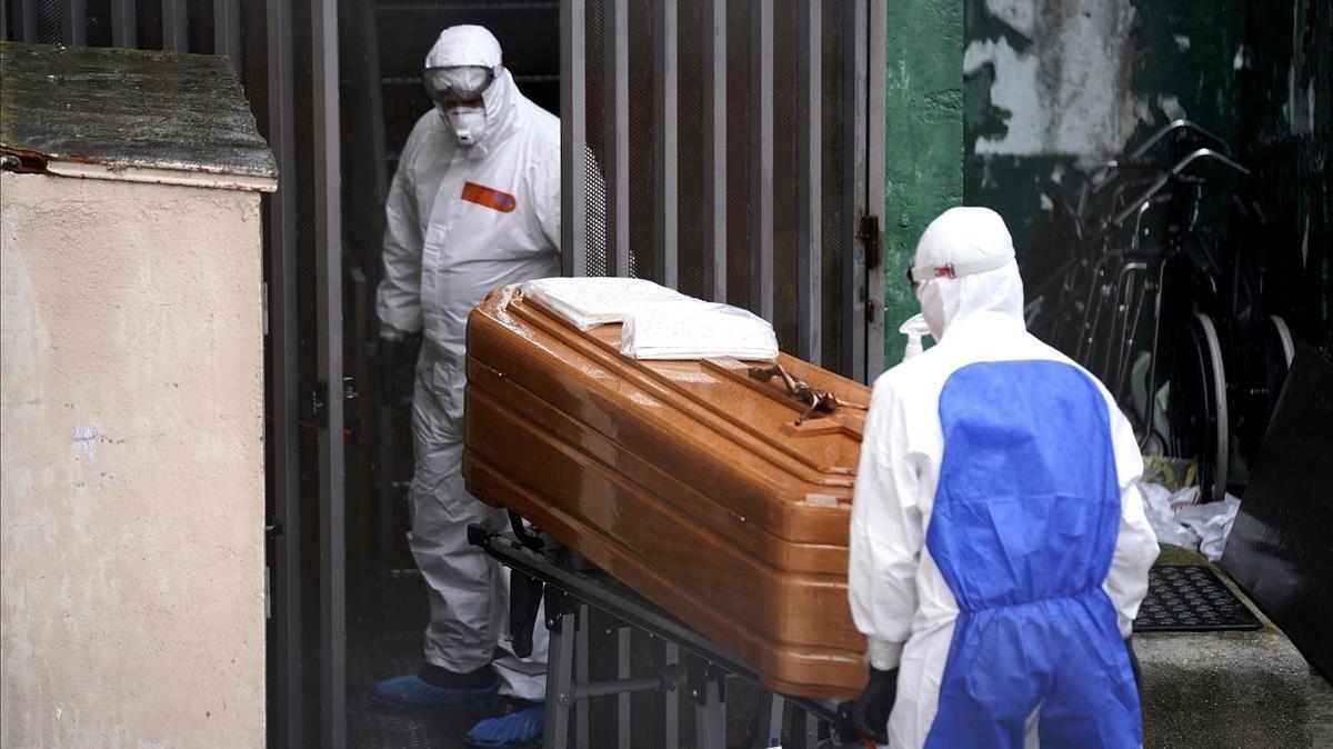 Operarios  de un servicio funerario se disponen a trasladar los cadaveres de varios ancianos fallecidos por coronavirus en el centro de mayores Vitalia, en la localidad madrileña de Leganés.