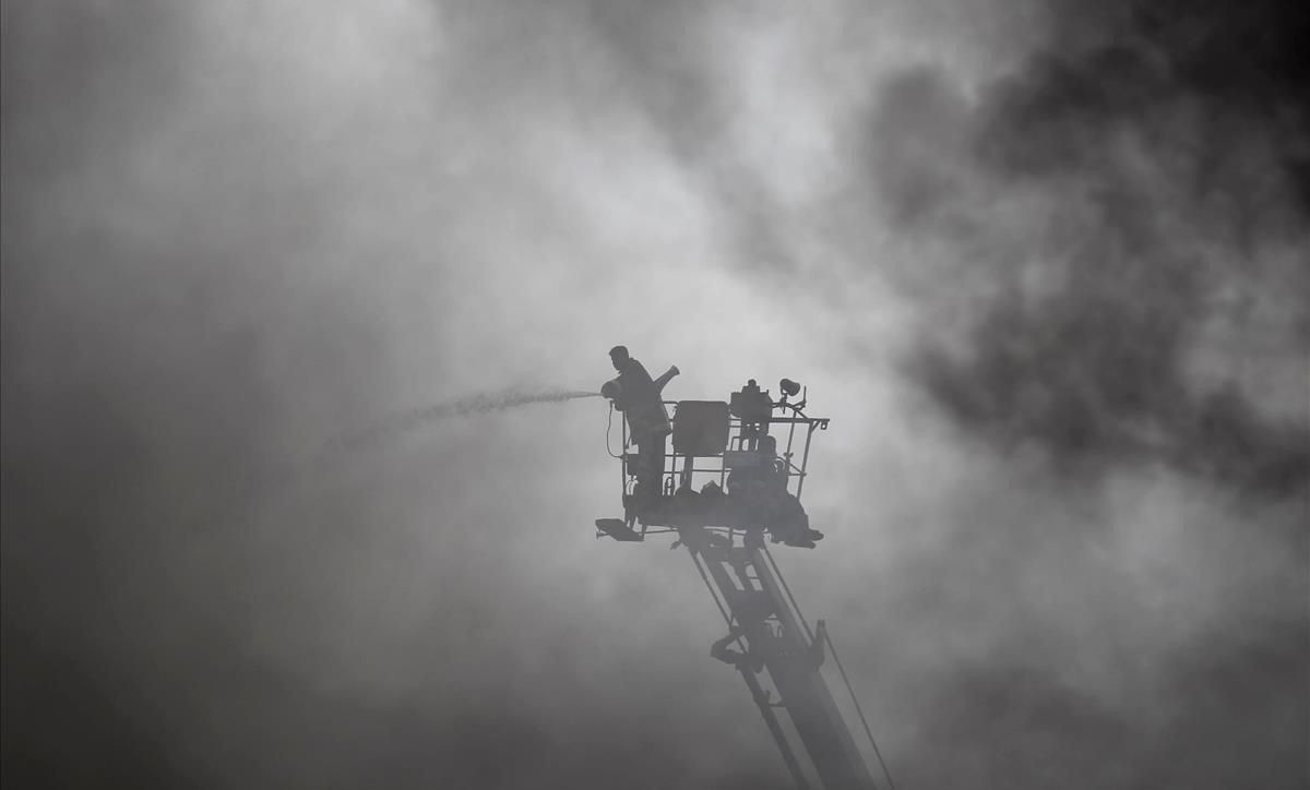 Tareas de extinción de un incendio en una industria de Bangladés. Tareas de extinción de un incendio en una industria de Bangladés.