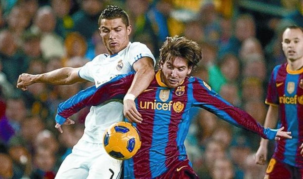Cristiano Ronaldo i Messi lluiten per la pilota en el Barça-Madrid de la primera volta de la Lliga. Cristiano Ronaldo i Messi lluiten per la pilota en el Barça-Madrid de la primera volta de la Lliga.