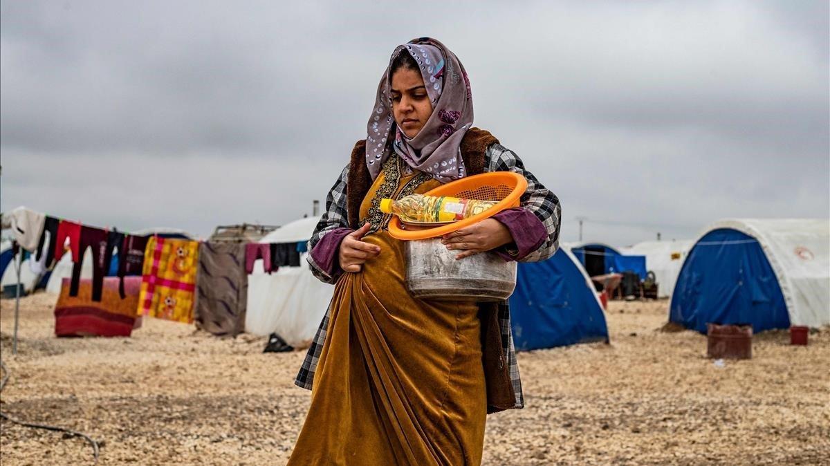 Una mujer embarazada camina por el campo de Washukanni, en el norte de Siria.