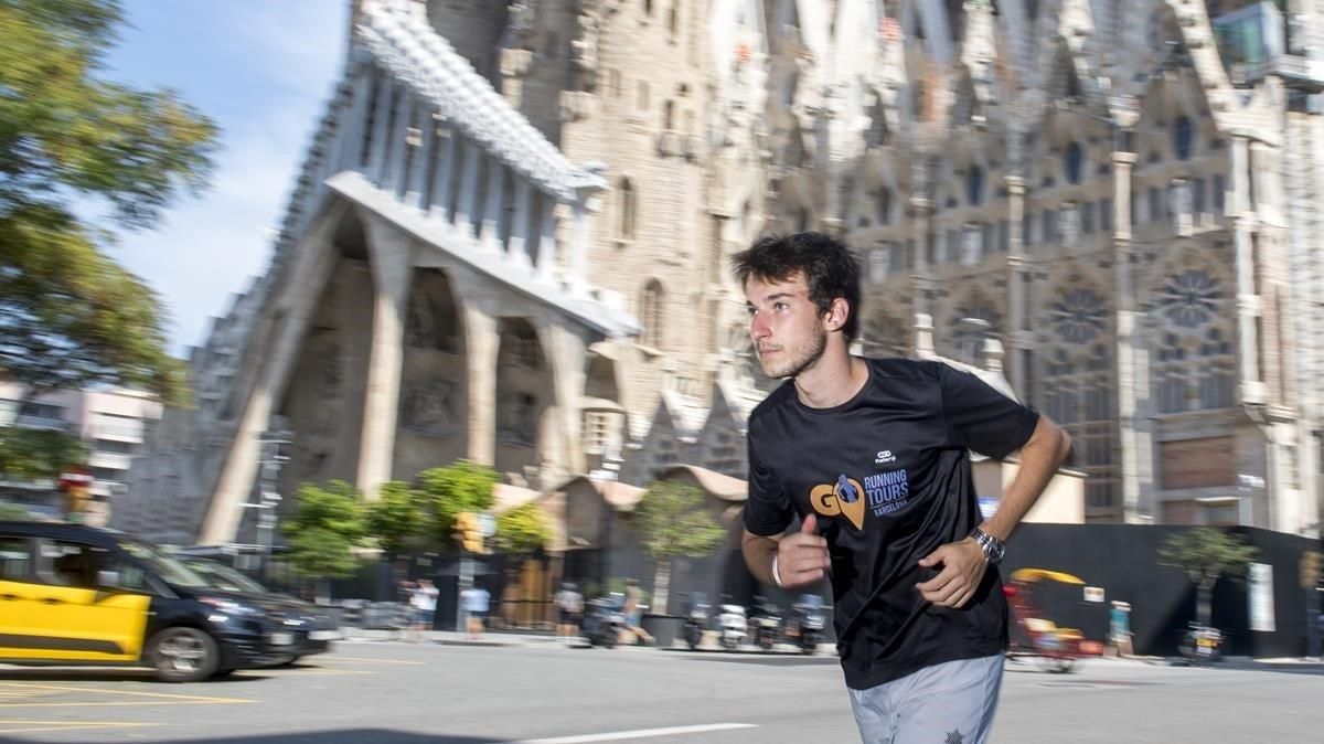 Luca Lande, el joven guía que muestra la ciudad mientras practica el ’running’ con turistas, corre junto a la Sagrada Familia. Luca Lande, el joven guía que muestra la ciudad mientras practica el ’running’ con turistas, corre junto a la Sagrada Familia.