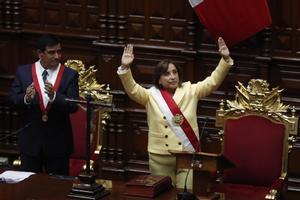 La abogada Dina Boluarte saluda tras ser juramentada como nueva presidenta del Perú por el presidente del Congreso, José Daniel Williams Zapata.