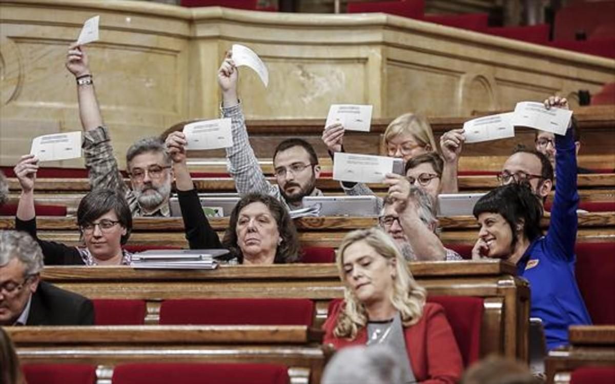 Los diputados de la CUP exhiben papeletas del eventual referéndum, ayer, en el debate del Parlament sobre los presupuestos. Los diputados de la CUP exhiben papeletas del eventual referéndum, ayer, en el debate del Parlament sobre los presupuestos.