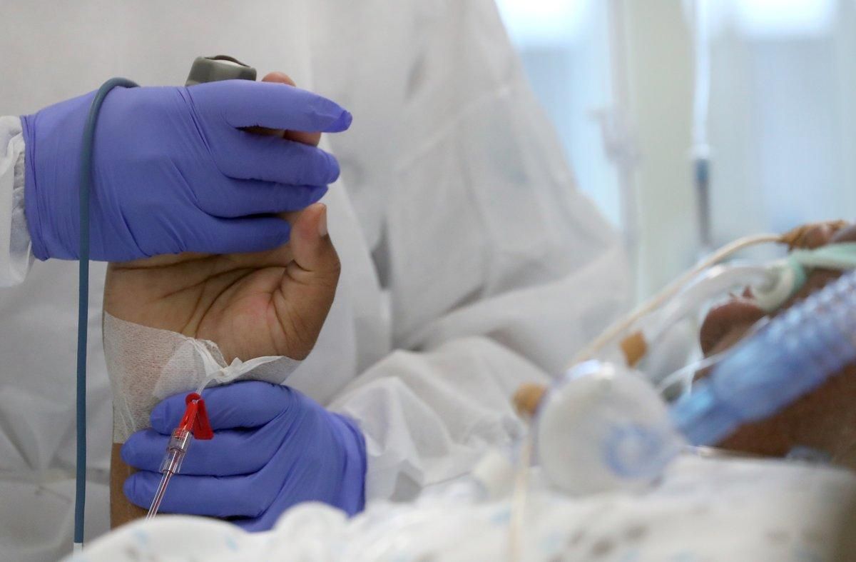 Un sanitario sostiene la mano a un paciente de covid-19 en un hospital de Bruselas, este viernes. Un sanitario sostiene la mano a un paciente de covid-19 en un hospital de Bruselas, este viernes.