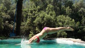 Una mujer se lanza a la piscina.