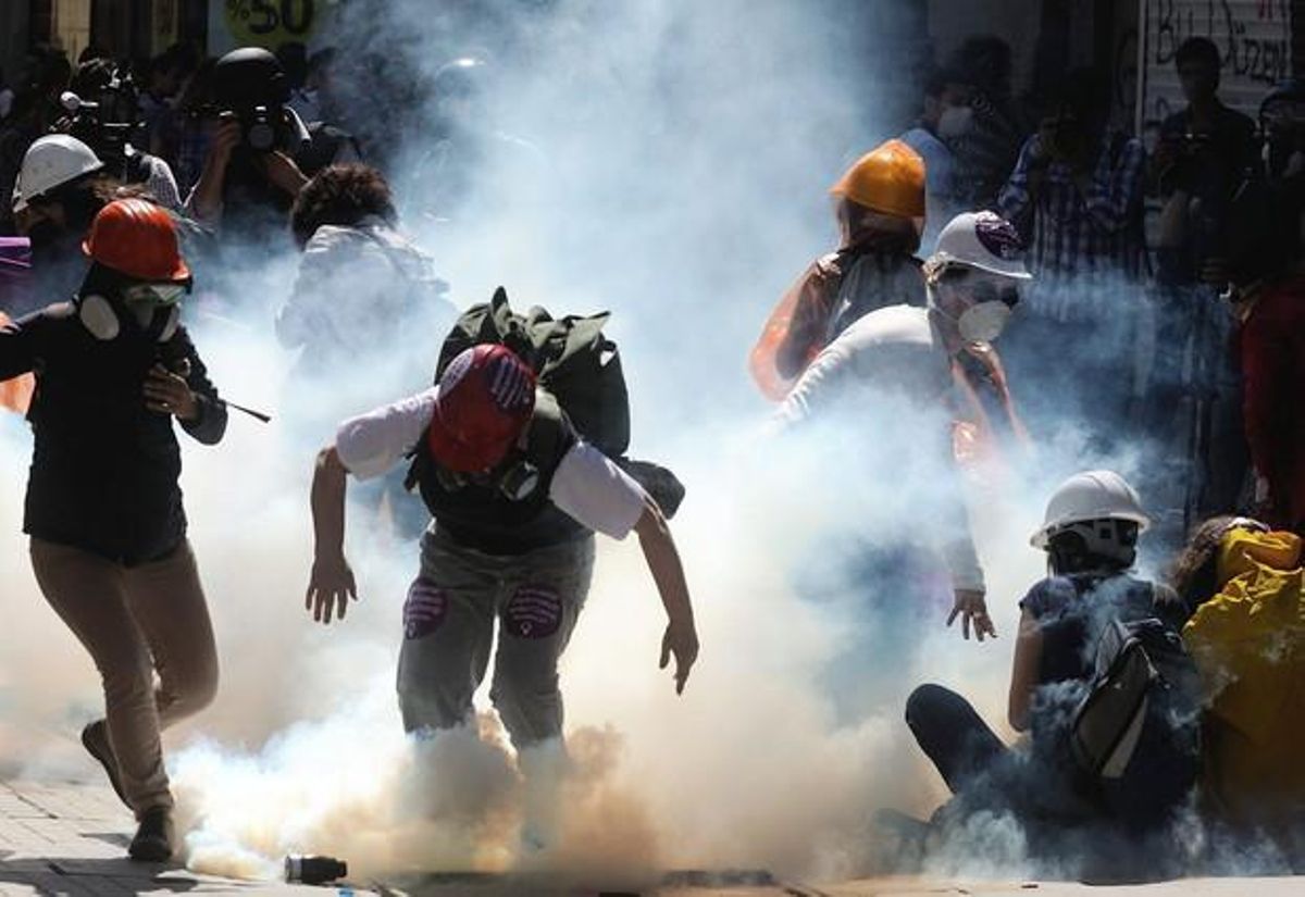 Manifestantes turcos corriendo para protegerse del gas lacrimógeno Manifestantes turcos corriendo para protegerse del gas lacrimógeno