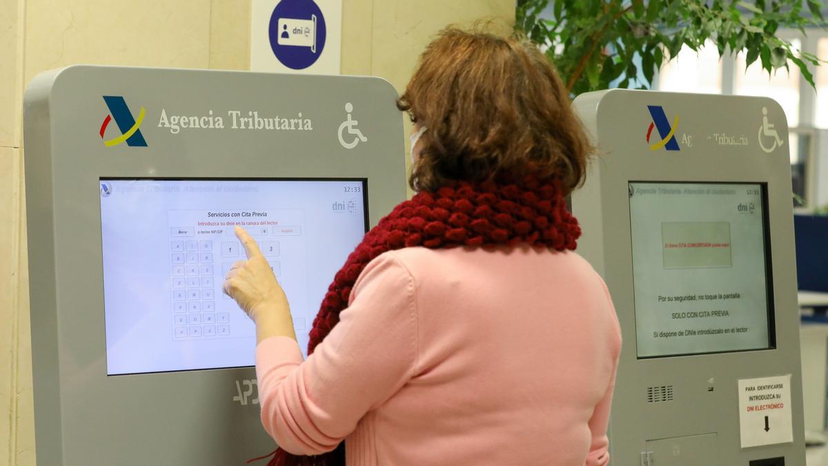 Una mujer recoge su turno en una oficina de la Agencia Tributaria en Madrid.