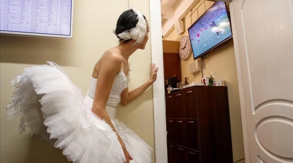 Una bailarina del teatro Mokhailovsky mira el partido entre Rusia y Croacia. Una bailarina del teatro Mokhailovsky mira el partido entre Rusia y Croacia.