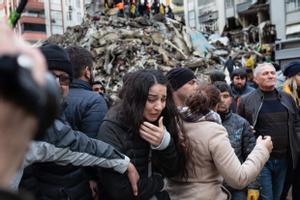 Una mujer llora ante un edificio derrumbado por el terremoto en Adana.