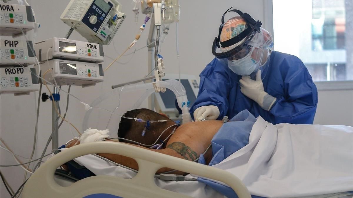 Una doctora controla el estado de un paciente ingresado en una uci. Una doctora controla el estado de un paciente ingresado en una uci.