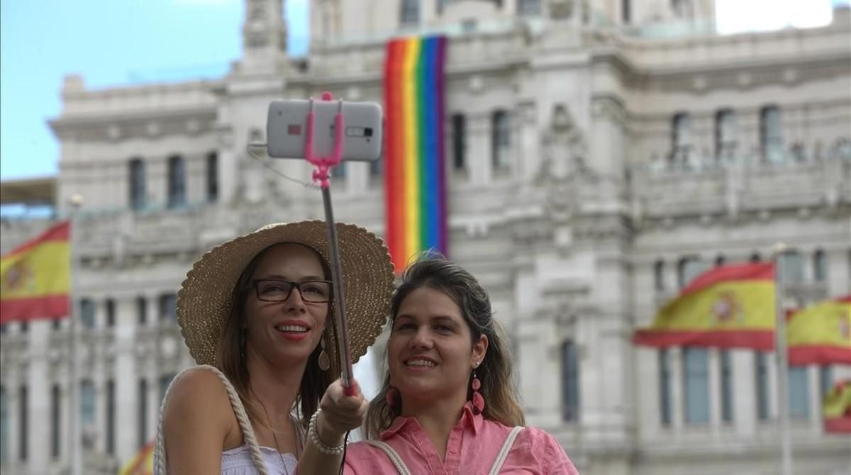 Dos turistas se hacen un ’selfie’ frente al Ayuntamiento de Madrid, que luce la bandera del arcoiris en homenaje al World Pride 2017. Dos turistas se hacen un ’selfie’ frente al Ayuntamiento de Madrid, que luce la bandera del arcoiris en homenaje al World Pride 2017.