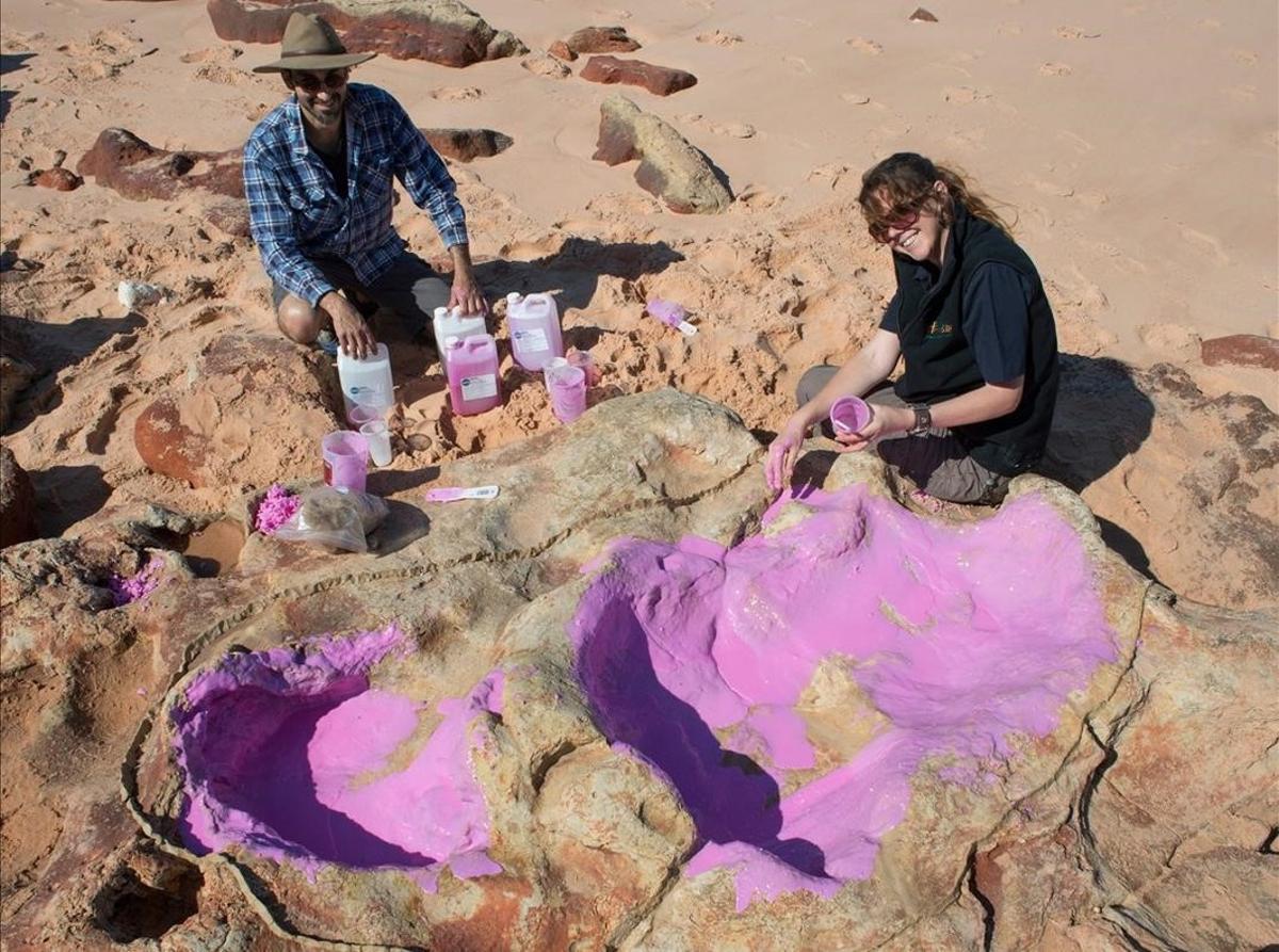 Los investigadores Anthony Romilio y Linda Pollard tratan de caracterizar la pisada de uin dinosaurio, en la península australiana de Dampier.